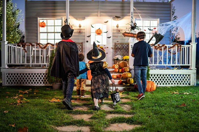 Young kids trick or treating at night during Halloween